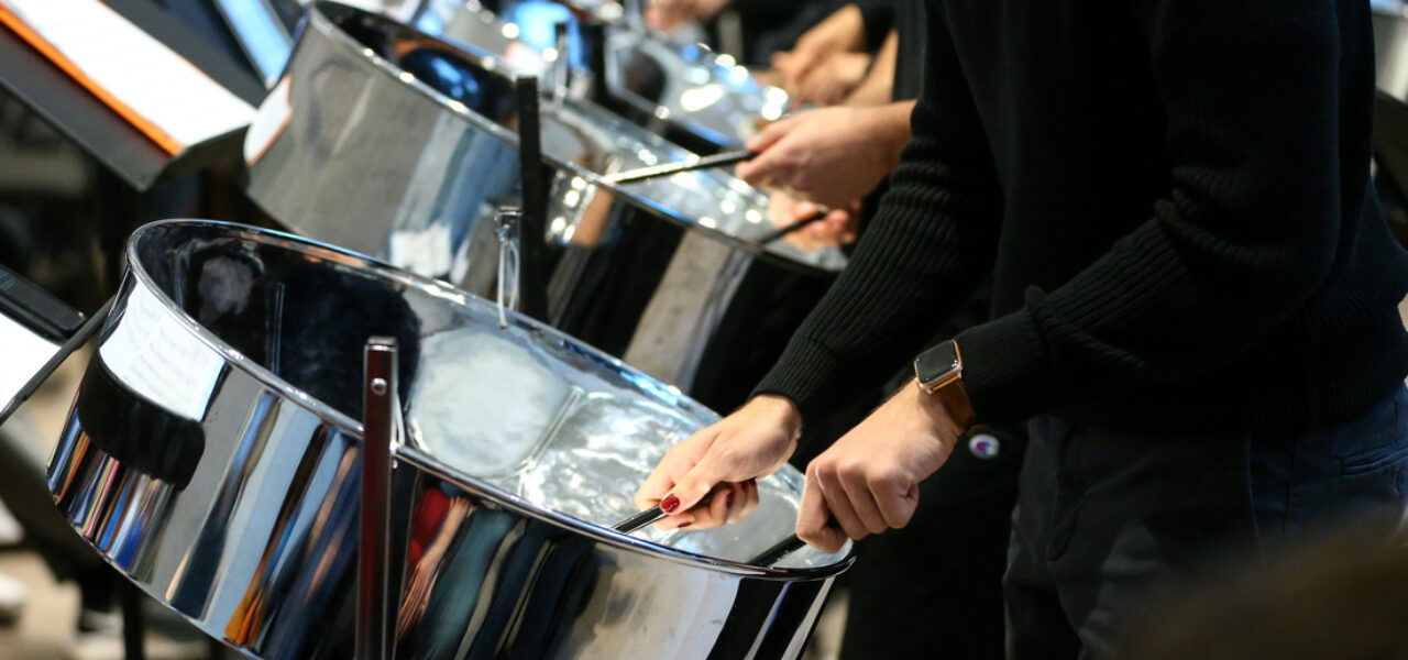 Photo of Princeton students playing steel pan drums, with a closeup on the drums