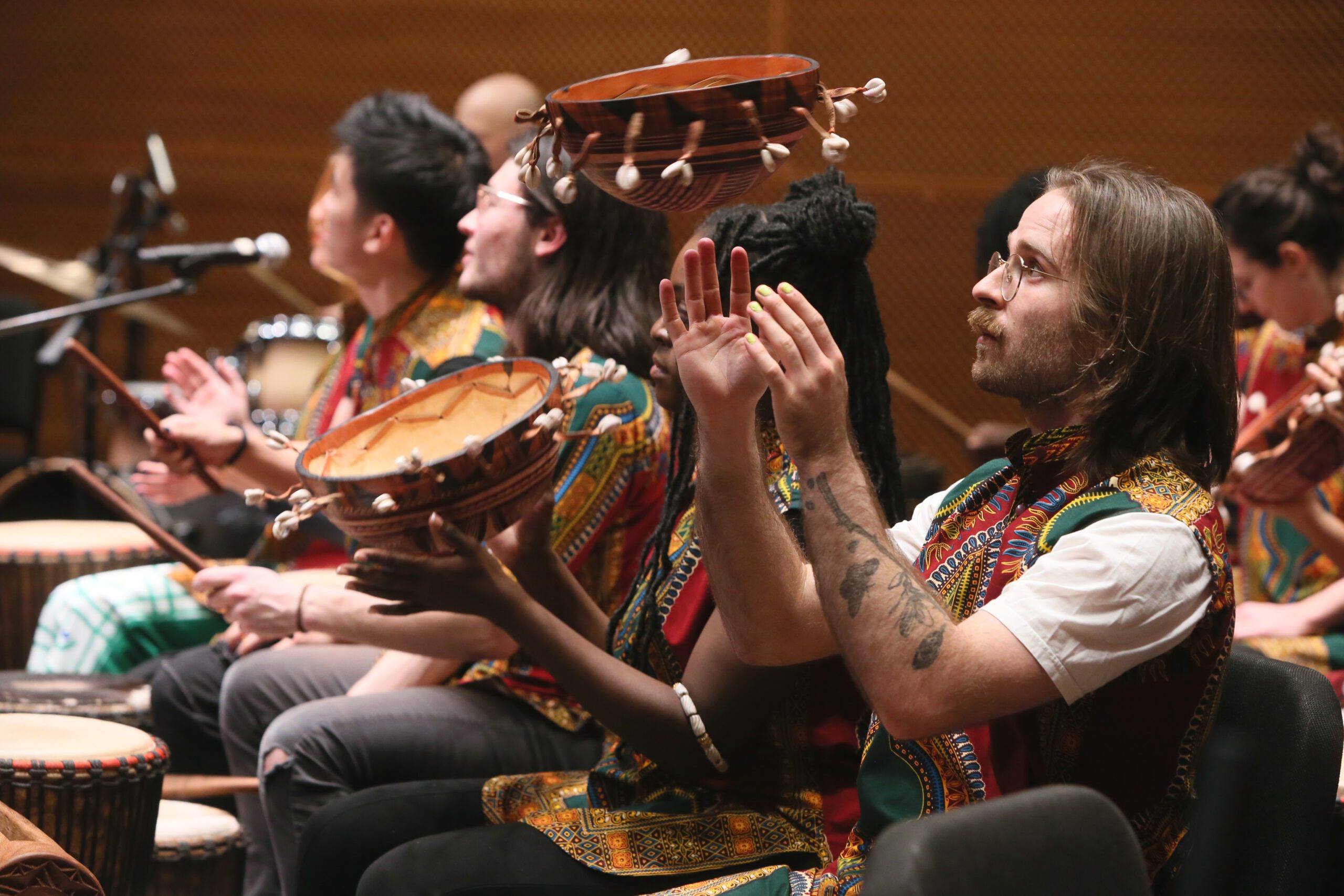 photo of African Music Ensemble performing , with performers playing African drums or clapping