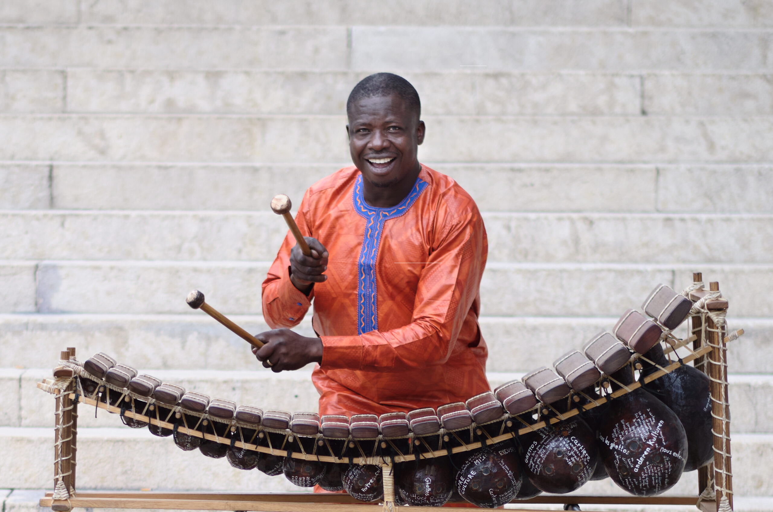 Mamadou Diabate smiling and playing an instrument