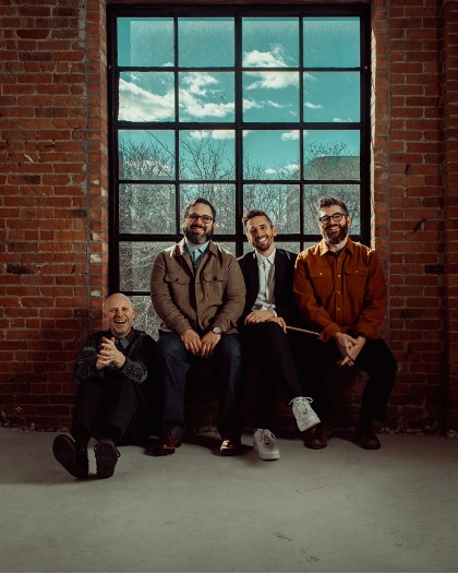 Four people sitting by a window