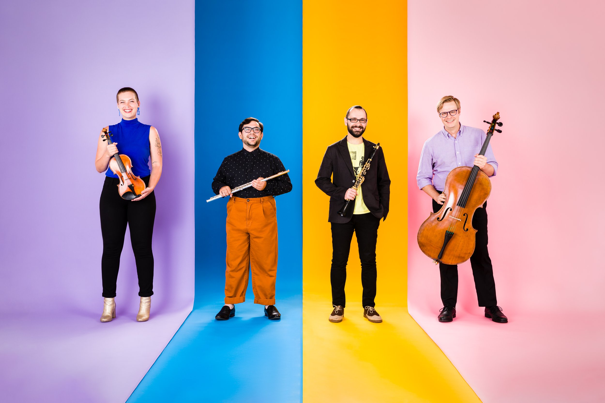 A group of musicians standing in front of a multi-colored background
